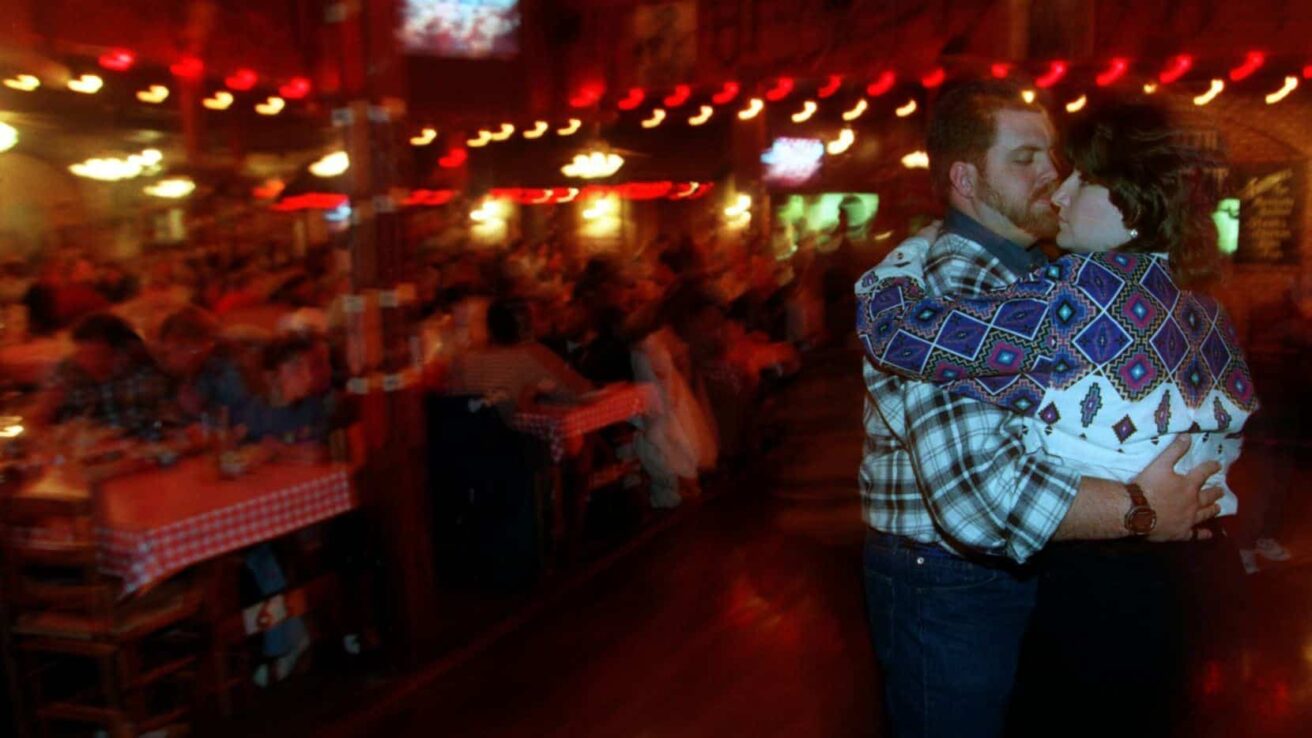 A man and woman hugging in a restaurant.