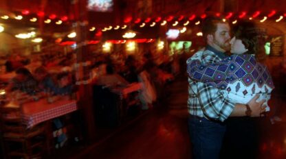 A man and woman hugging in a restaurant.