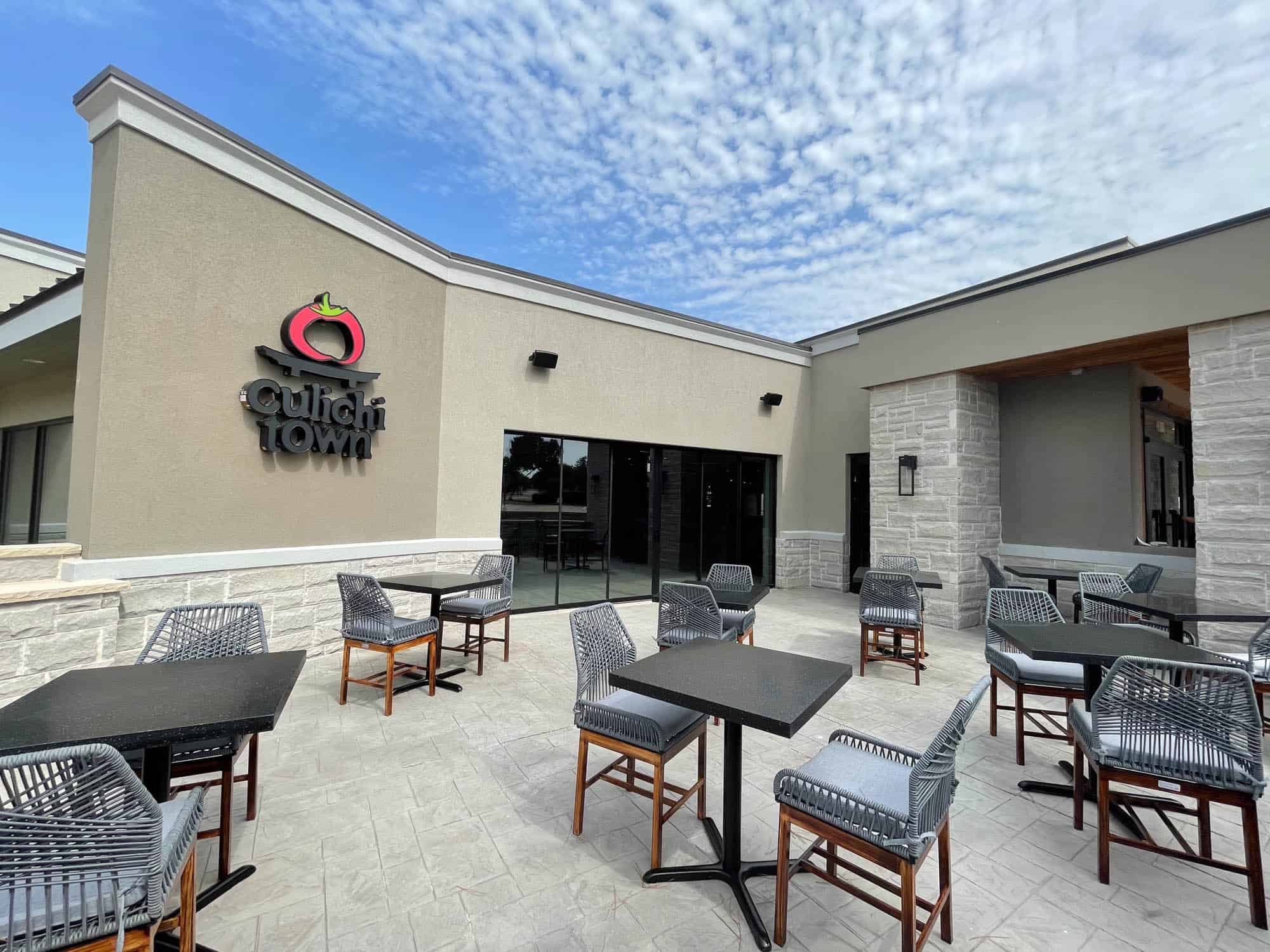 The patio of a restaurant with tables and chairs.