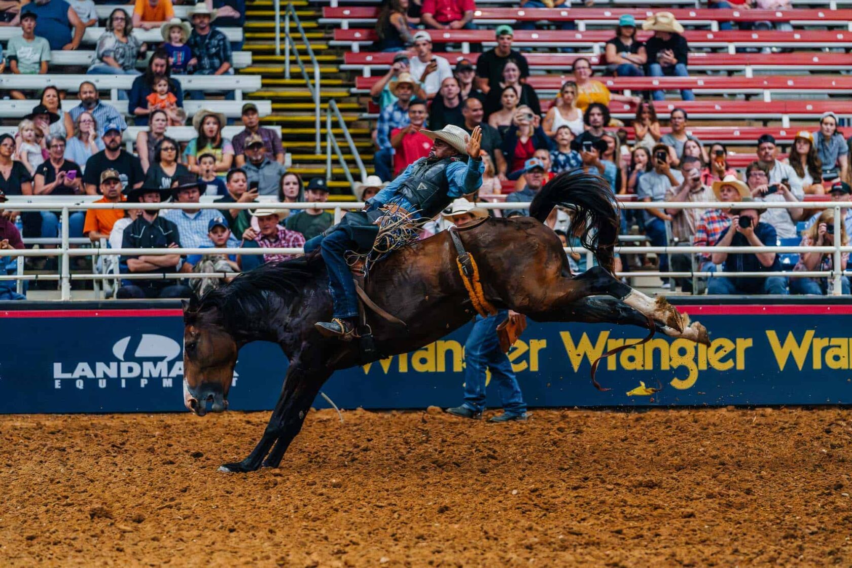 A man riding a horse at a rodeo.