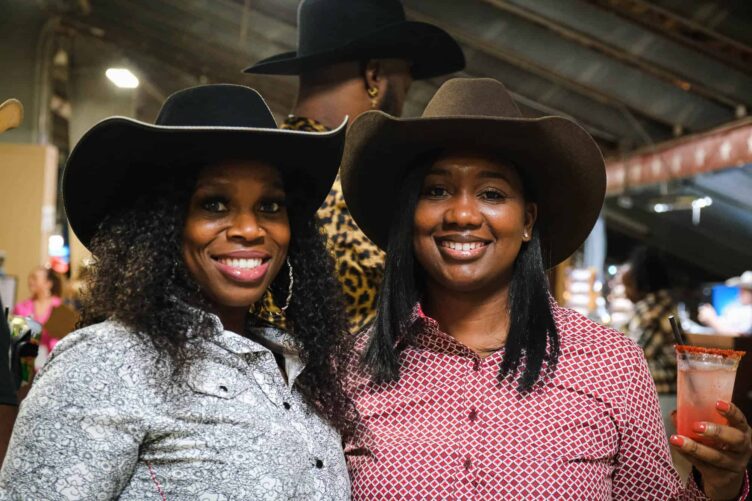 Two women in cowboy hats posing for a photo.