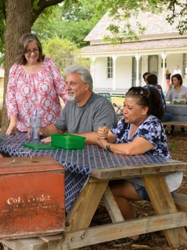 A group of people sitting around a picnic table.