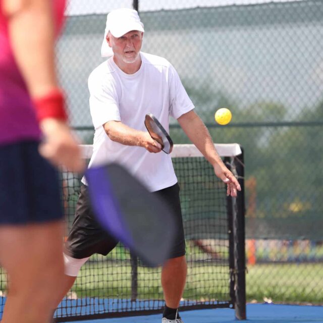 A man and woman playing tennis on a court.