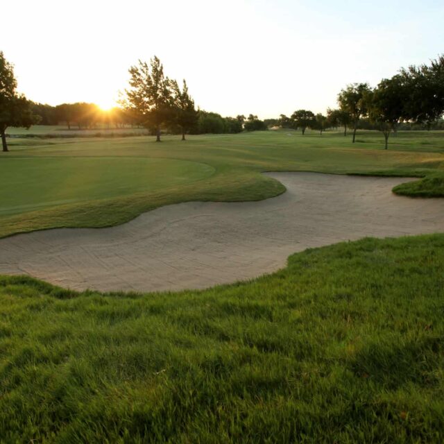 A golf course with a sand bunker.