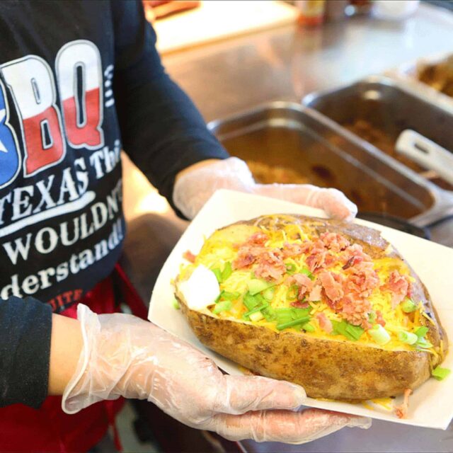 A person holding a plate of food.