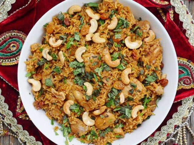 A bowl of rice with nuts and cashews.