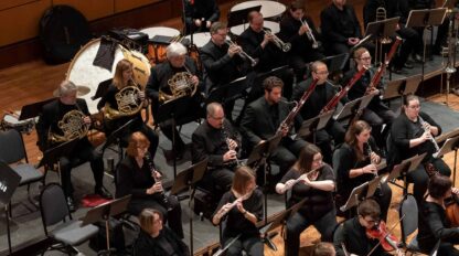 Symphony orchestra in a large auditorium.